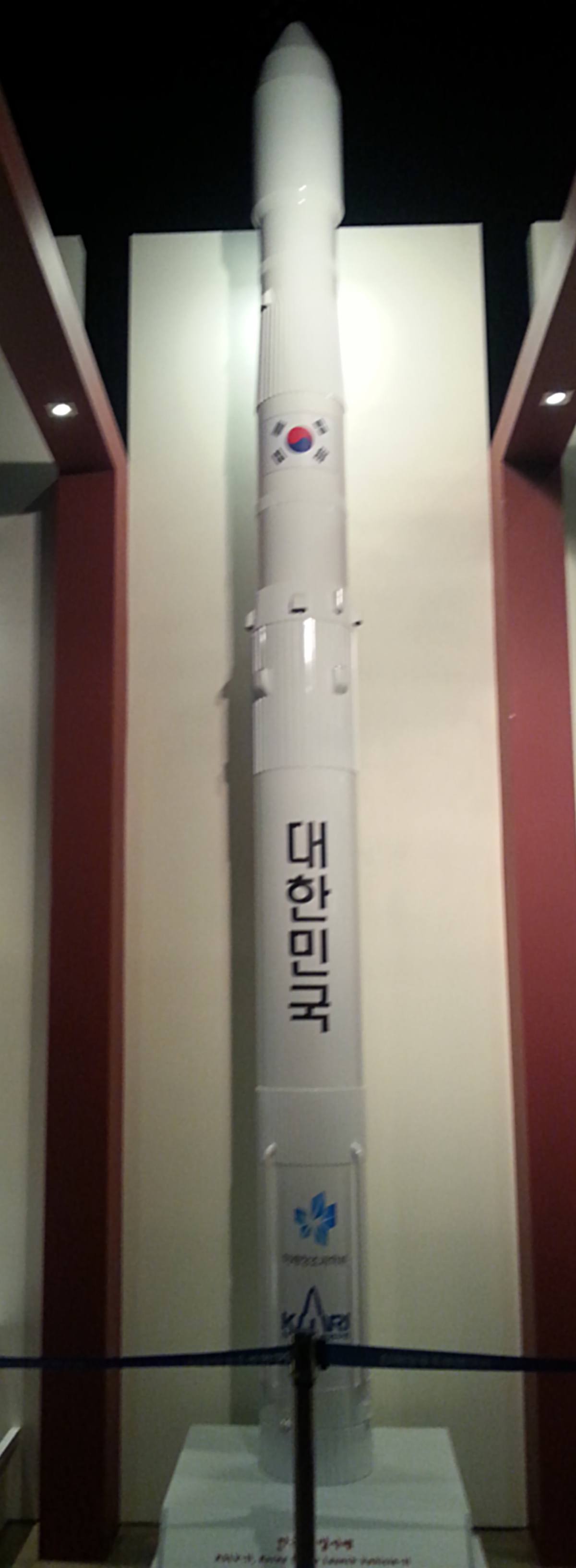 A white rocket replica stands upright outdoors.