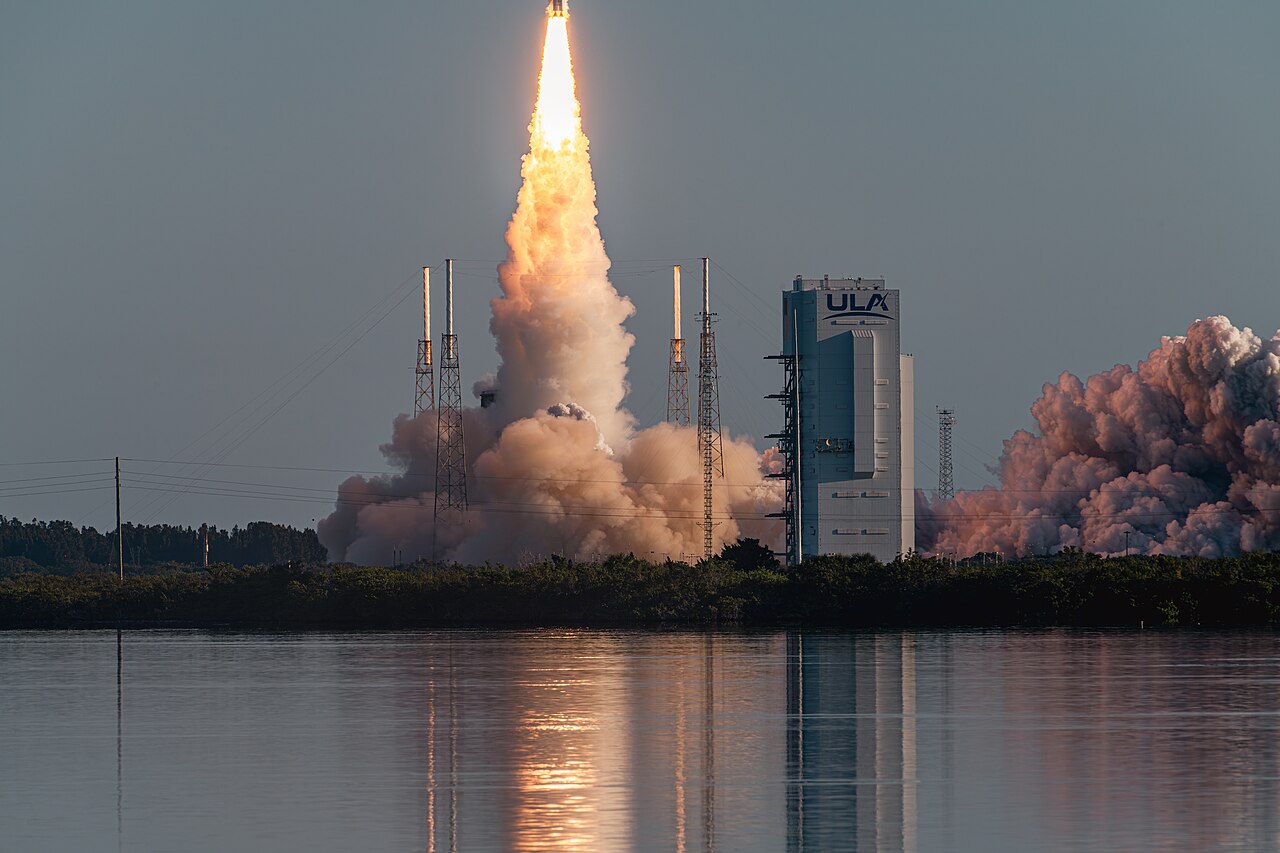 An Atlas V rocket launches into a cloudy sky.