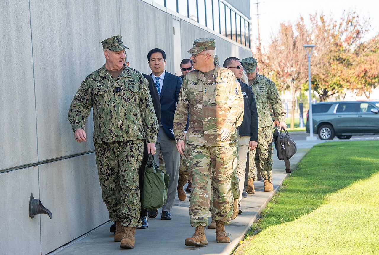 U.S. Navy Adm. Christopher W. Grady and U.S. Space Force Lt. Gen. Philip Garrant walk and converse.