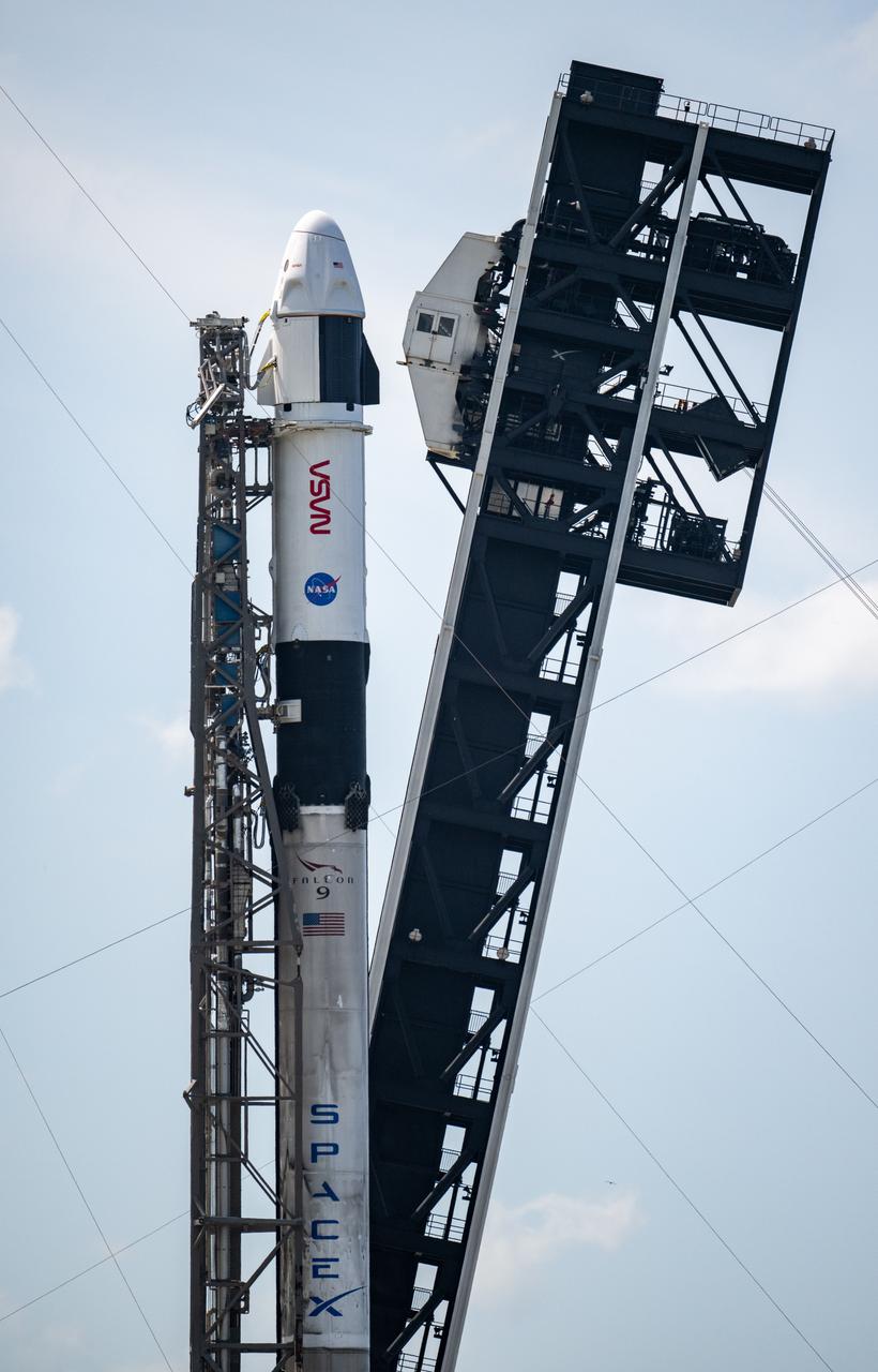 A SpaceX Falcon 9 rocket with Dragon spacecraft on the launch pad.